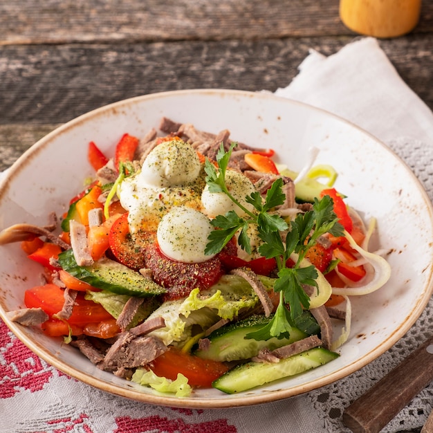 Verdure di insalata della carne ed uova di quaglia su superficie rustica di legno