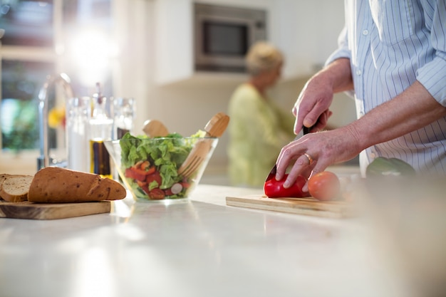 Verdure di taglio dell'uomo senior per insalata