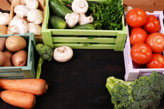 Verdure diverse in scatole su sfondo di legno vista dall'alto