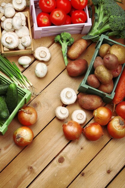 Verdure diverse in scatole su sfondo di legno vista dall'alto