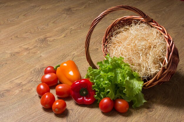 Verdure e cesto di legno sul tavolo