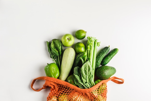 Verdure e frutta verdi in sacchetto di corda arancione