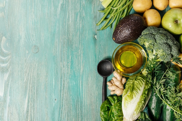 Verdure e olio sul tavolo di legno