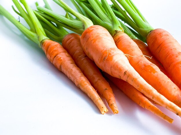 Verdure fresche a radice di carota su sfondo bianco