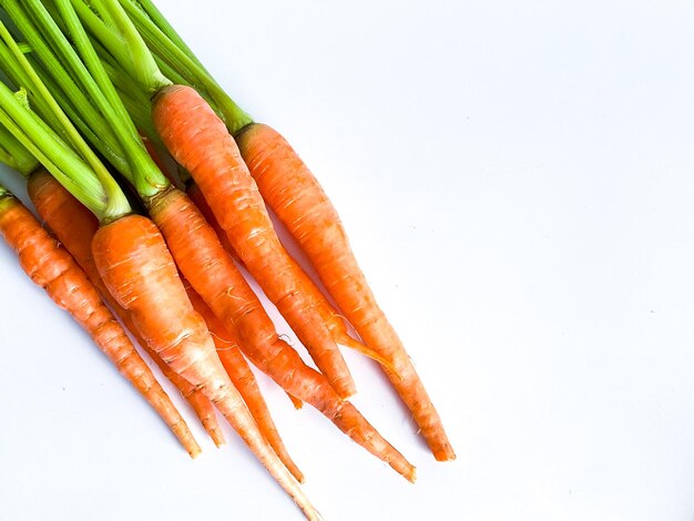 Verdure fresche a radice di carota su sfondo bianco