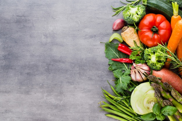 Verdure fresche bio sui precedenti di pietra grigia