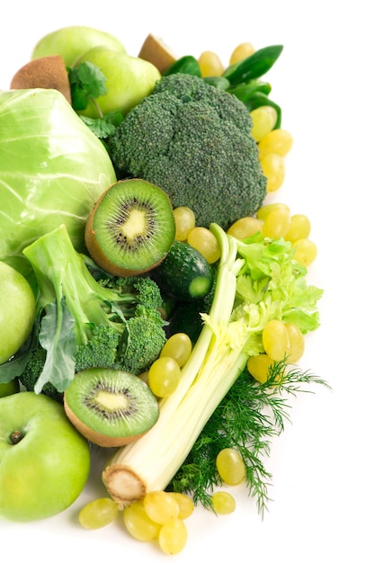 Verdure fresche con foglie - broccoli, kiwi, sedano, spinaci, cavoli, uva e mela isolati su superficie bianca