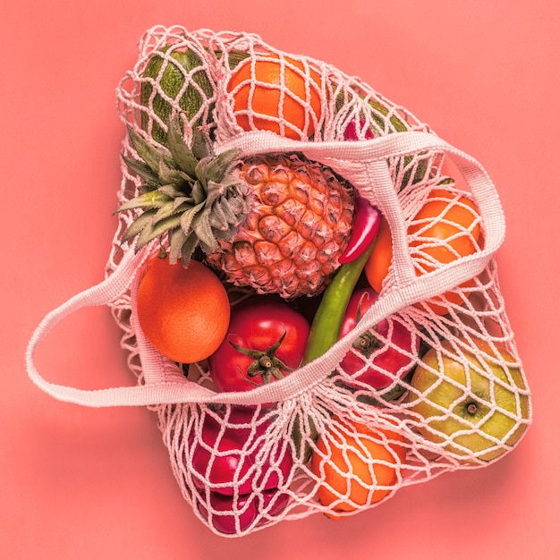 Verdure fresche e frutta in maglia di borsa, vista dall'alto.