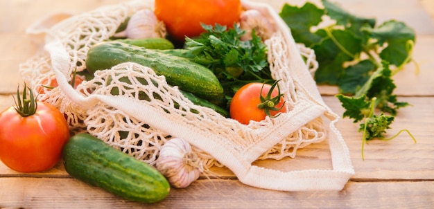 Verdure fresche e succose prodotti in una borsa della spesa riutilizzabile un sacchetto di corda fatto di materiali riciclati su un tavolo di legno in giardino Vegetarianismo Nessuna plastica Stile di vita ecologico