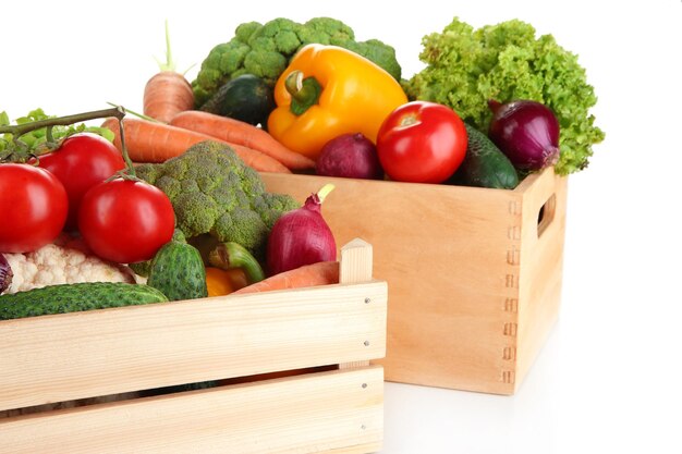 Verdure fresche in scatole di legno su sfondo bianco