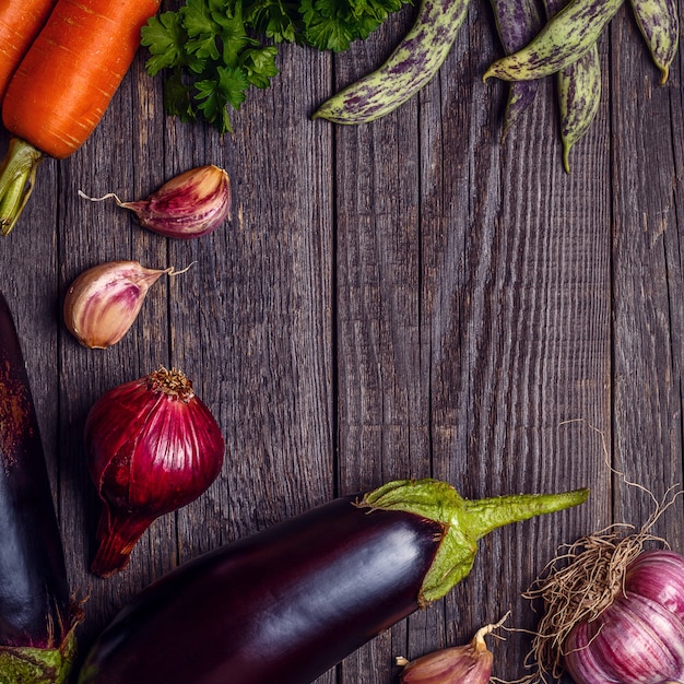 Verdure fresche per la cottura su legno scuro con spazio per il testo.