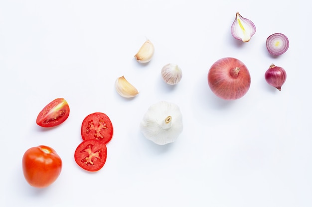 Verdure fresche su sfondo bianco. Pomodoro, cipolla rossa, aglio,