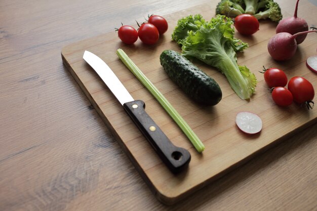 Verdure fresche su un tagliere su un tavolo di legno