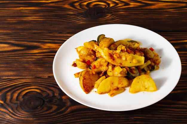 verdure fritte sul piatto bianco e sulla tavola di legno