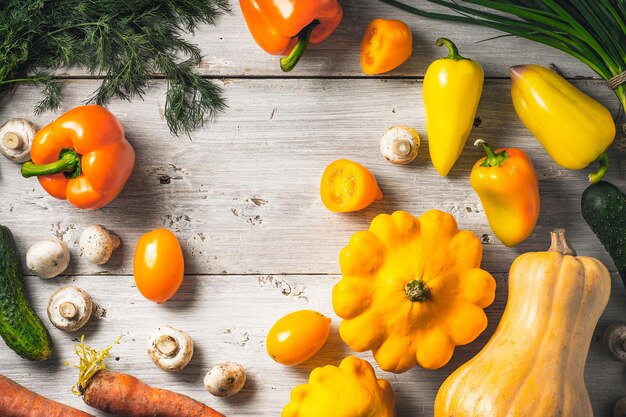 Verdure gialle e verdi sulla tavola di legno bianca