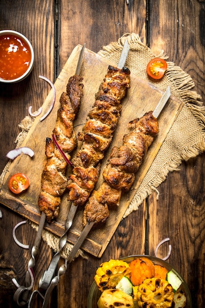 Verdure grigliate con un fragrante shish kebab di montone.Su fondo di legno.