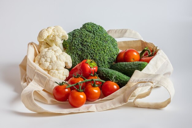 Verdure in borsa in tessuto riutilizzabile su sfondo bianco