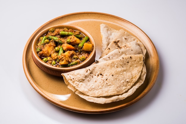 Verdure miste indiane contenenti patate e fagioli con masala tradizionale e curry servite con chapati o roti o focaccia indiana