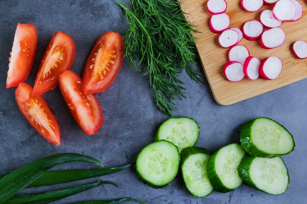 Verdure per insalata: cetrioli, pomodori, ravanelli, cipolle verdi e aneto.