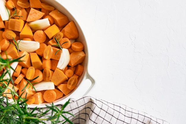 Verdure preparate per la cottura in una ciotola bianca su sfondo bianco