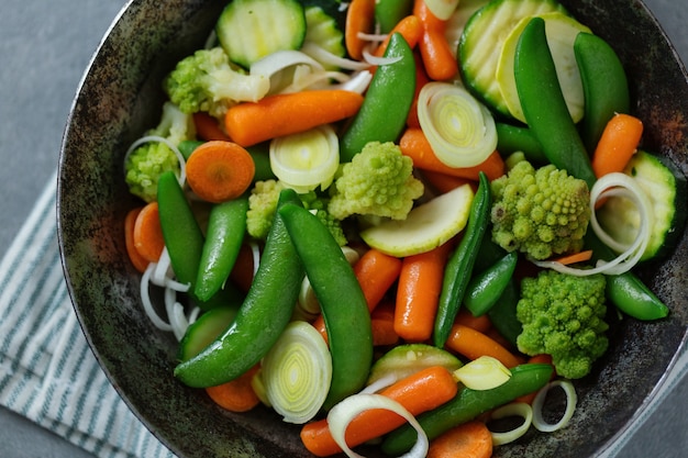 Verdure vegane in padella fritte o pronte per la cottura sul tavolo