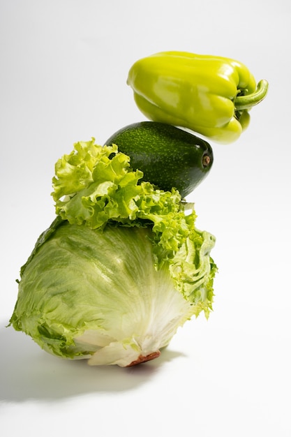 Verdure verdi fresche su sfondo grigio. Equilibrio alimentare di insalata, peperone e avocado.Verticale