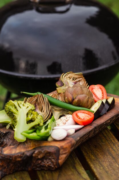 Verdure vicino alla griglia Grigliate verdi Preparazione per cucinare cibi vegani sani sul fuoco Carciofo fresco pomodoro peperone e verdure diverse