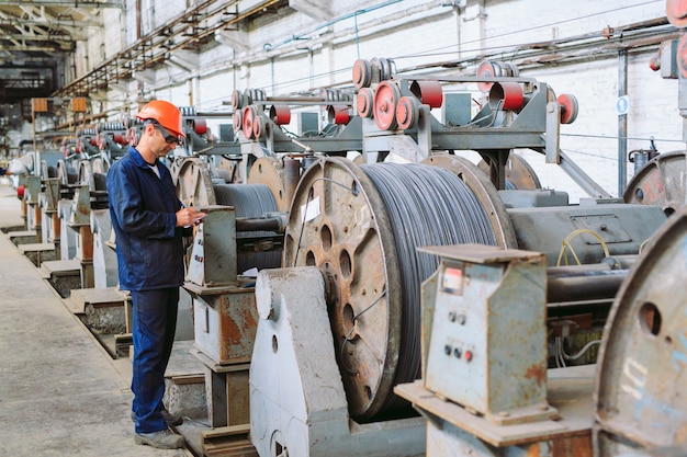 Vergella, accessori nei magazzini. lavoratore a fianco di un fascio con catalkoy. magazzino industriale nello stabilimento metallurgico.