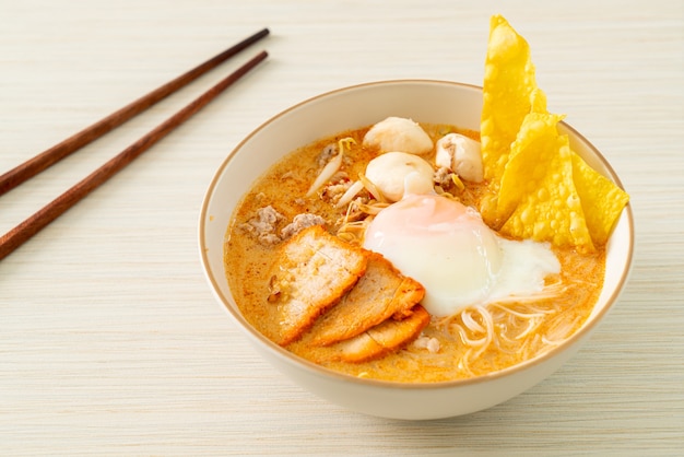 Vermicelli di riso con polpette, maiale arrosto e uova in zuppa piccante - Tom Yum Noodles