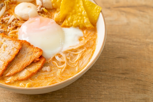 Vermicelli di riso con polpette, maiale arrosto e uova in zuppa piccante - Tom Yum Noodles