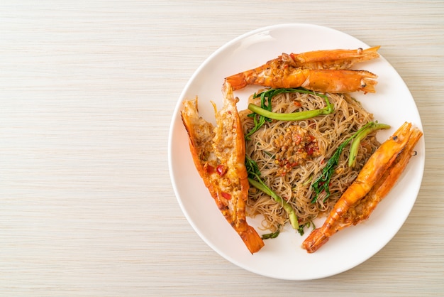 Vermicelli di riso saltati in padella e mimosa d'acqua con gamberi di fiume su piatto