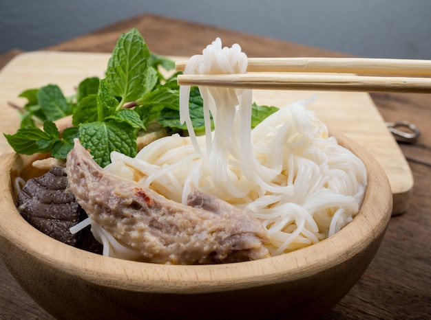 Vermicelli tailandesi con curry e la verdura in ciotola di legno