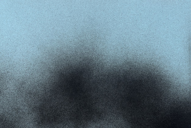 Vernice spray nera su uno sfondo di carta colorata blu