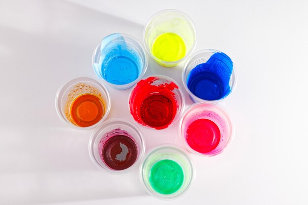 Vernici colorate essiccate in bicchieri di plastica