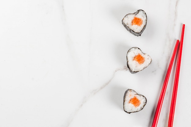 Vero sushi impostato per San Valentino a forma di cuore. Vista superiore dello spazio di marmo bianco della copia del fondo