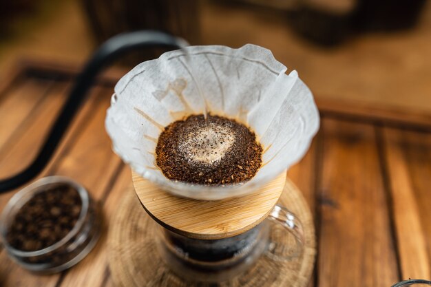 Versa l'acqua calda nel caffè., gocciola il caffè su un tavolo di legno a casa