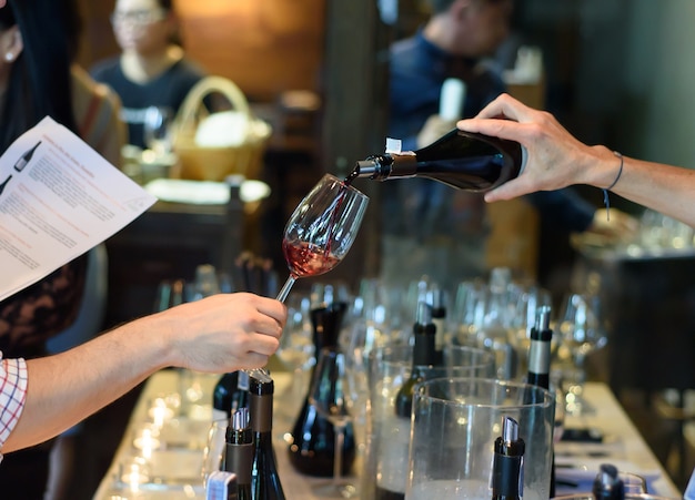 versando vino rosso dalla bottiglia nei bicchieri