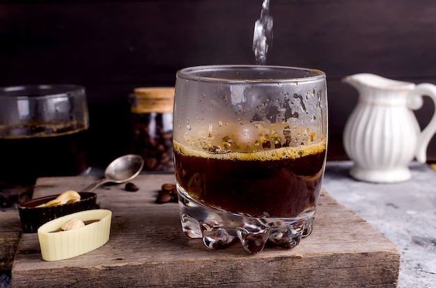 Versare acqua bollente in un bicchiere di caffè