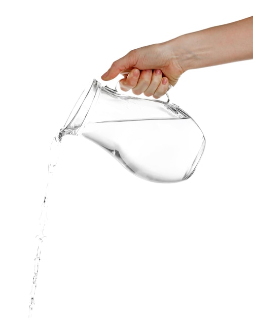 Versare acqua da una brocca di vetro isolata su bianco