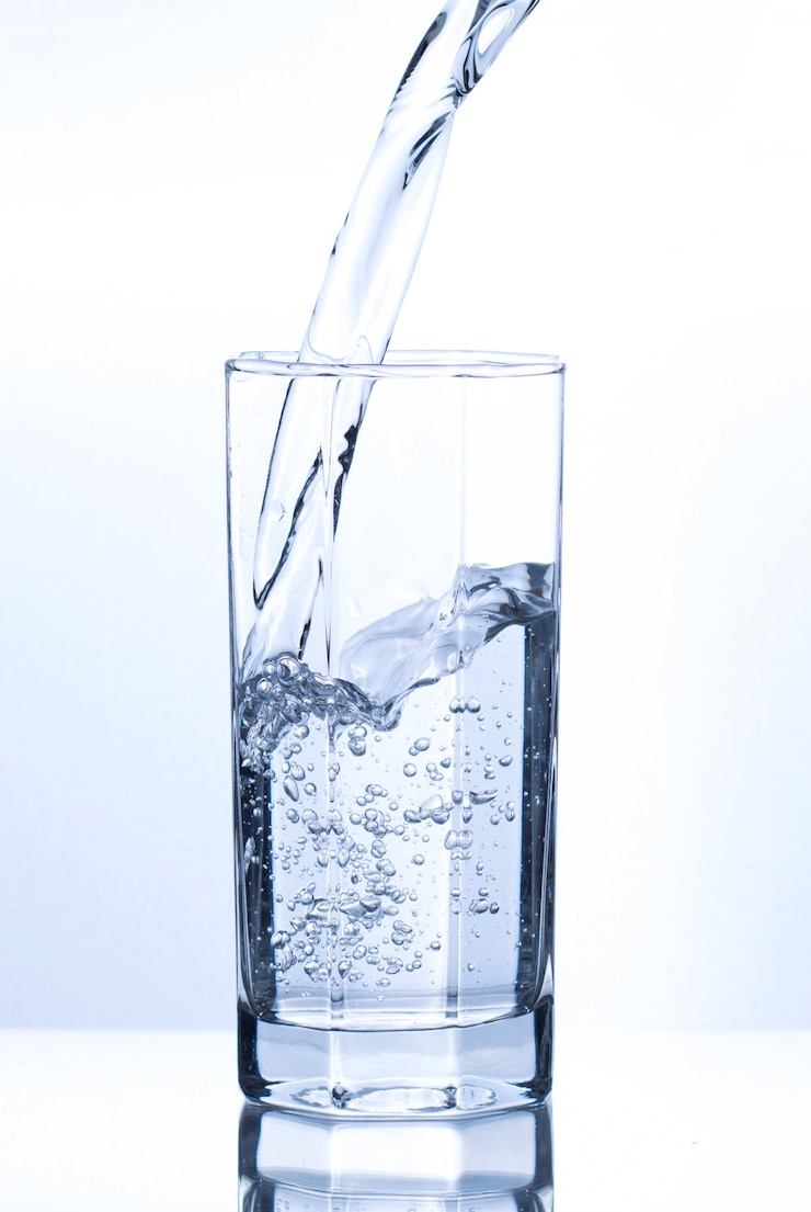 Foto versare acqua trasparente in vetro con bolle