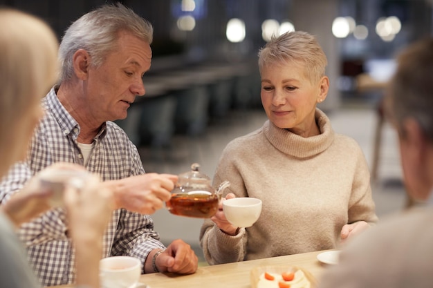 Versare il tè nella tazza della signora