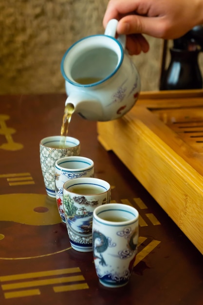 Versare il tè verde in bicchieri alla cerimonia del tè cinese