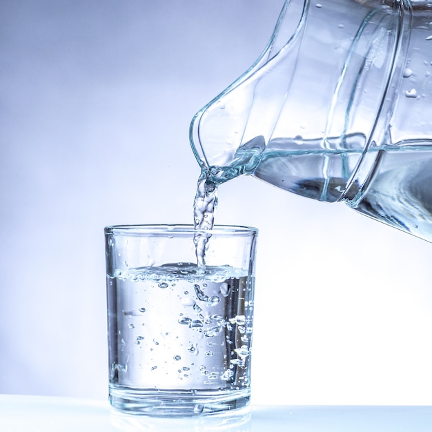 Versare l'acqua dalla brocca in un bicchiere