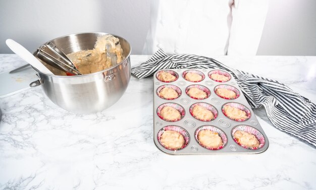 Versare la pastella di banana bread in una teglia per muffin per cuocere i muffin.