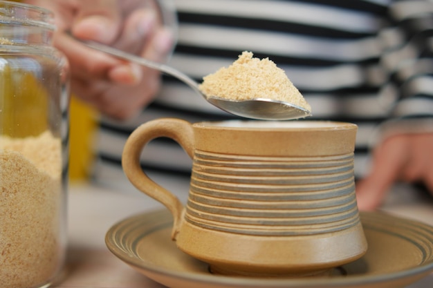 Versare lo zucchero bianco in una tazza di caffè