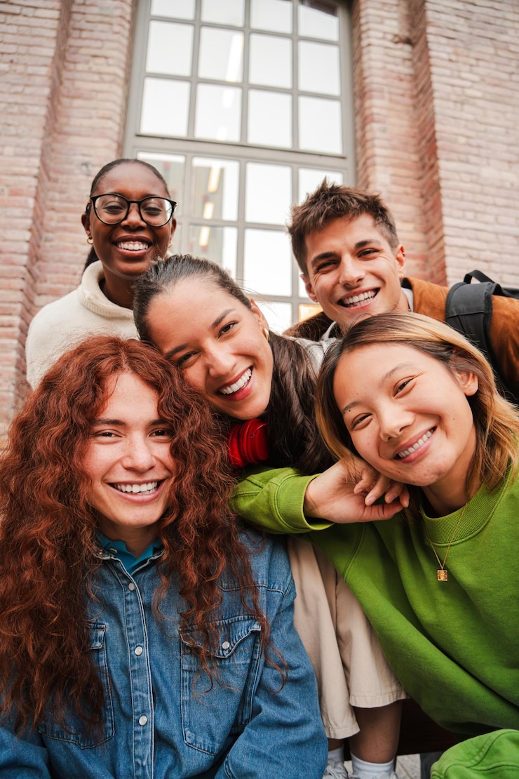 Vertical portrait of a group of friends having fun and smiling together high school students looking