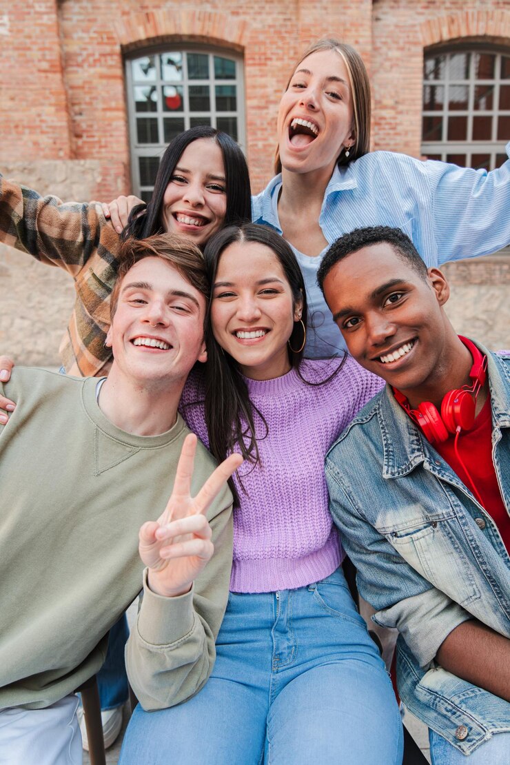 Vertical portrait of happy international teenagers laughing cheerful friends having fun classmates