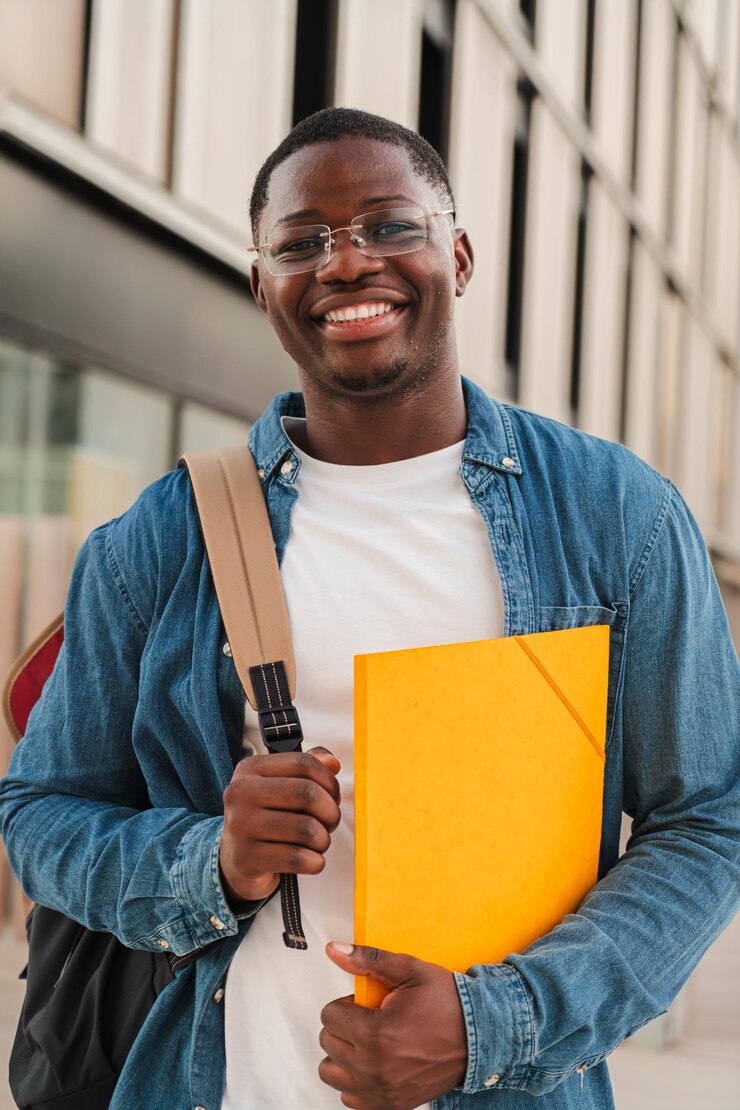 Vertical smiling african american student looking at the camera holding a folder and wearing a