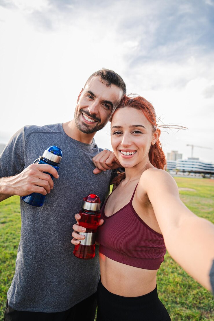 Vertical sport couple taking a selfie portrait after the cardio workout smiling and looking at