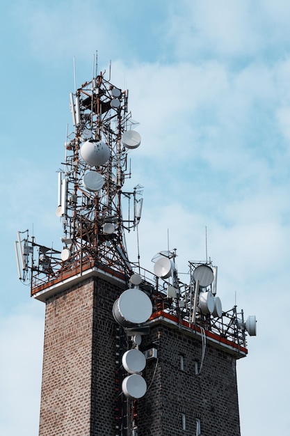 Verticale di una torre di telecomunicazione contro il cielo blu nuvoloso